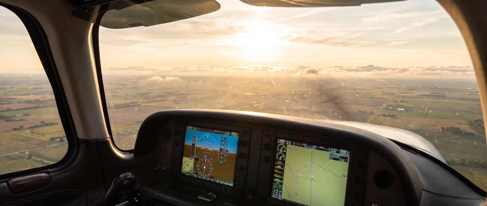 Cirrus SR22 cockpit view over the glass panel toward a golden hour horizon (AI-generated)